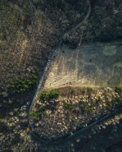 An aerial view of the road surrounded by rocks and trees